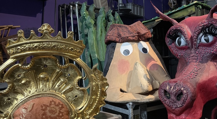 Kulisselager hos Frilynt med gullstol, stort ansikt og Shrek-dragen plassert på flightkasser blant ulike rekvisitter.