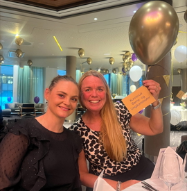 Bilde av Anne Merete Andreassen og en annen dame på Frilynt Norges jubileum. Holder kort med ballong i hånden.